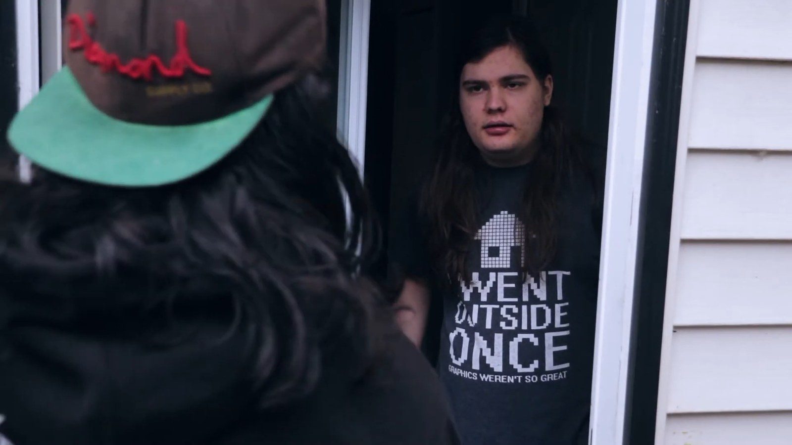 A teen in a "I Went Outside Once, Graphics Weren't So Great" t-shirt answers his door to a friendly neighbor
